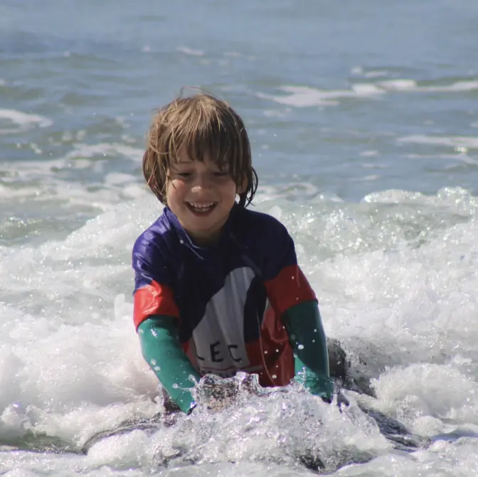 Enfant qui rit dans les vagues aux Lecques
